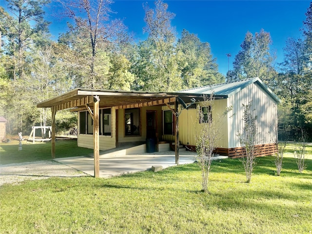 back of property featuring a carport and a yard