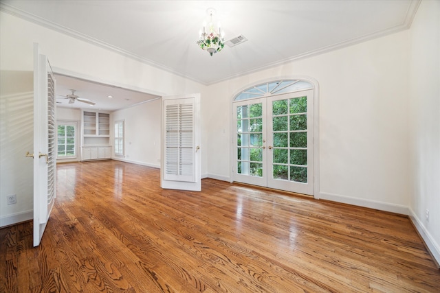 unfurnished living room with a healthy amount of sunlight, wood-type flooring, and french doors