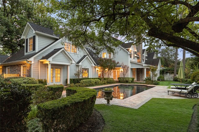 back of property featuring french doors, a yard, and a patio area