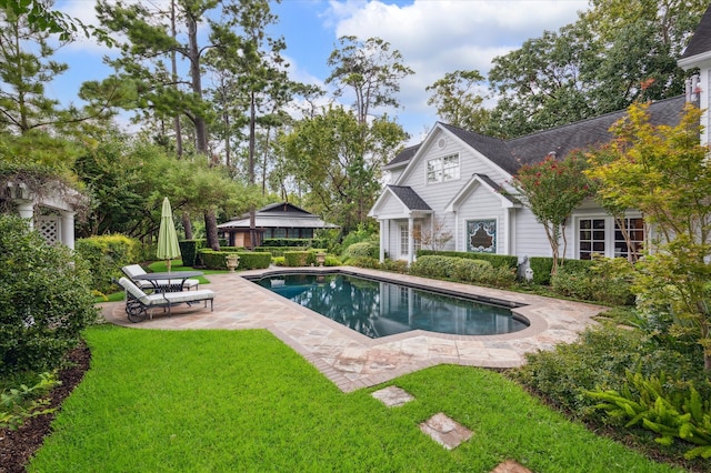 view of swimming pool featuring a lawn and a patio