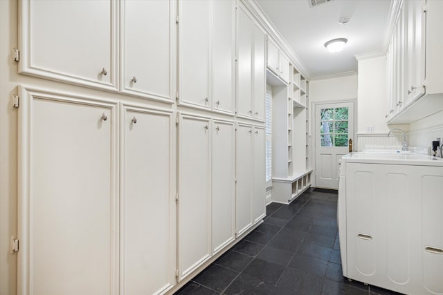 washroom with washer / clothes dryer, sink, cabinets, and ornamental molding