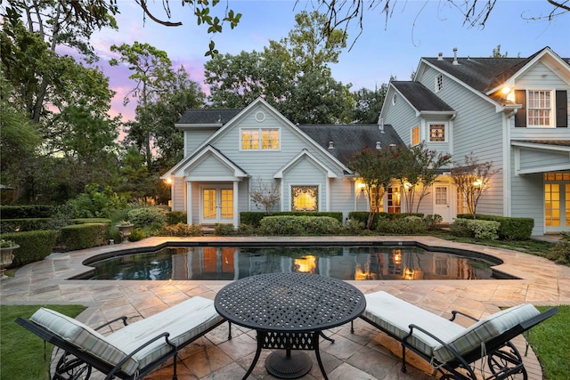 back house at dusk with a patio