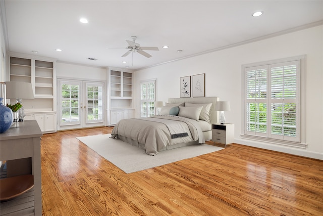 bedroom with access to exterior, french doors, light wood-type flooring, ceiling fan, and crown molding