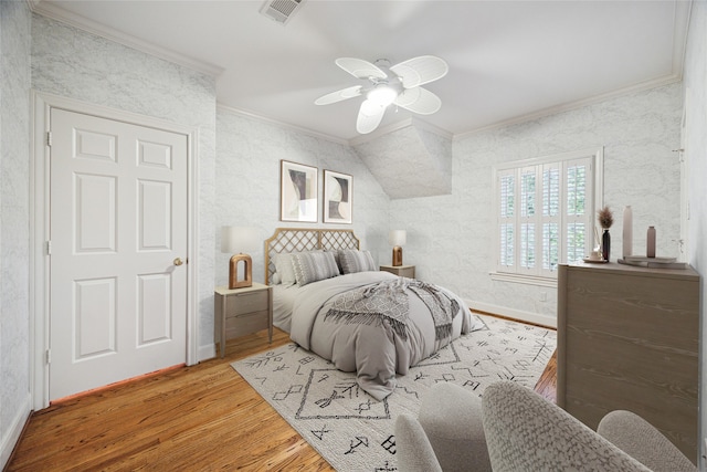 bedroom with lofted ceiling, hardwood / wood-style flooring, ceiling fan, and ornamental molding