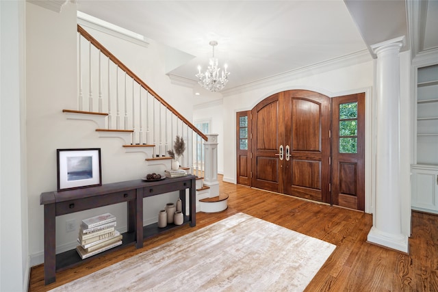 foyer featuring a notable chandelier, light hardwood / wood-style floors, and crown molding