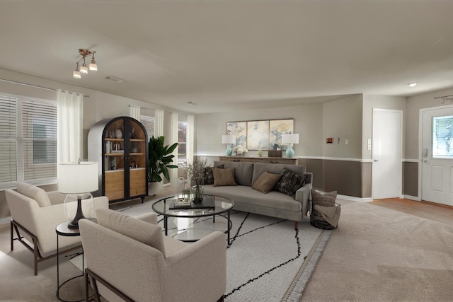 living room featuring light colored carpet and a healthy amount of sunlight