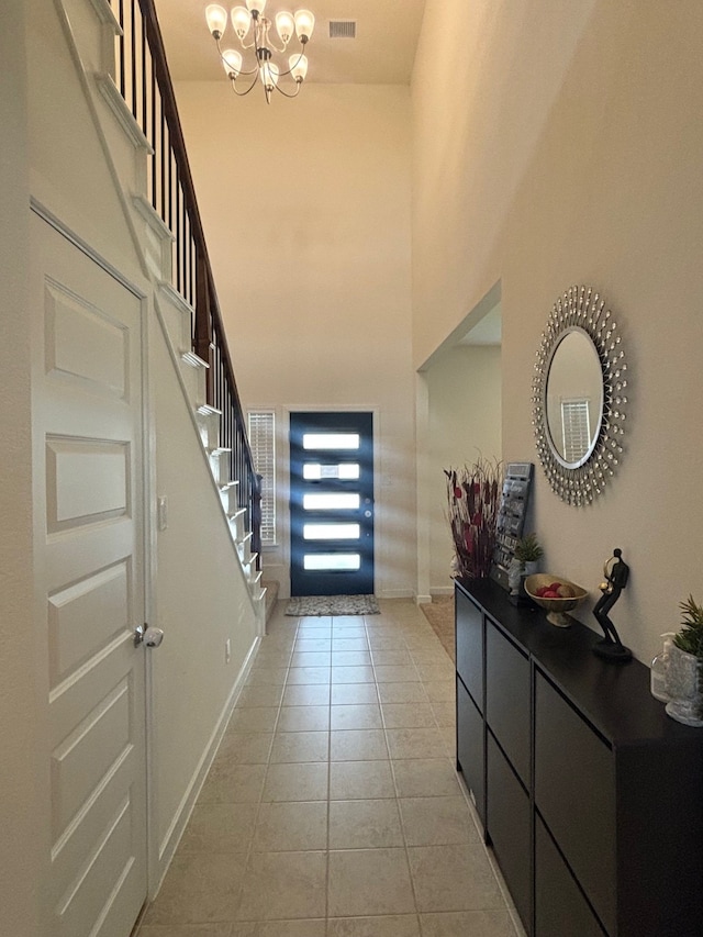 tiled foyer with a high ceiling and an inviting chandelier