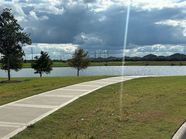 view of property's community with a water view and a yard