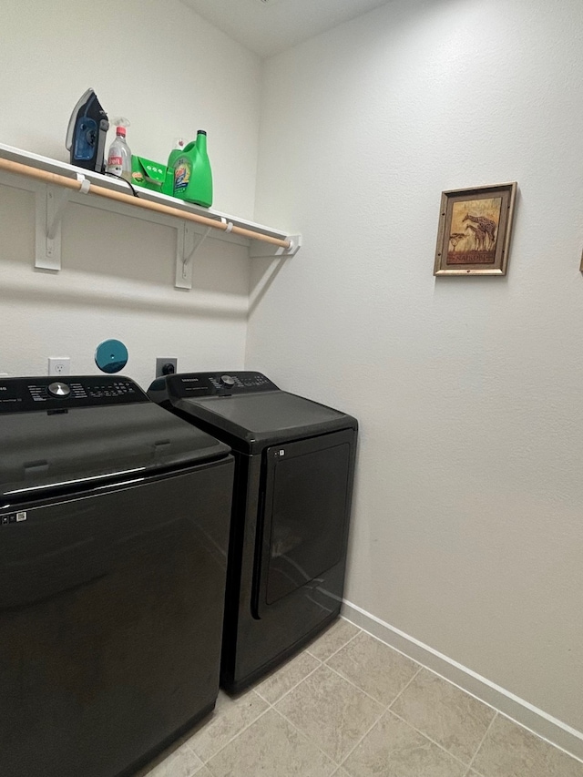 clothes washing area with separate washer and dryer and light tile patterned floors