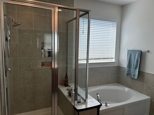 bathroom featuring separate shower and tub