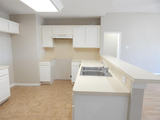 kitchen featuring sink, white cabinets, and kitchen peninsula