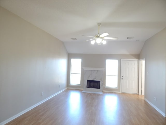 unfurnished living room with a fireplace, ceiling fan, vaulted ceiling, and light hardwood / wood-style flooring