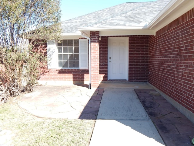 view of exterior entry with a patio area