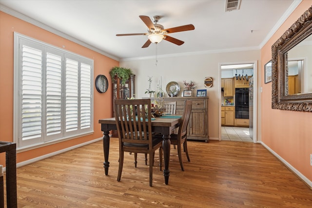 dining area with light hardwood / wood-style floors, ceiling fan, and ornamental molding