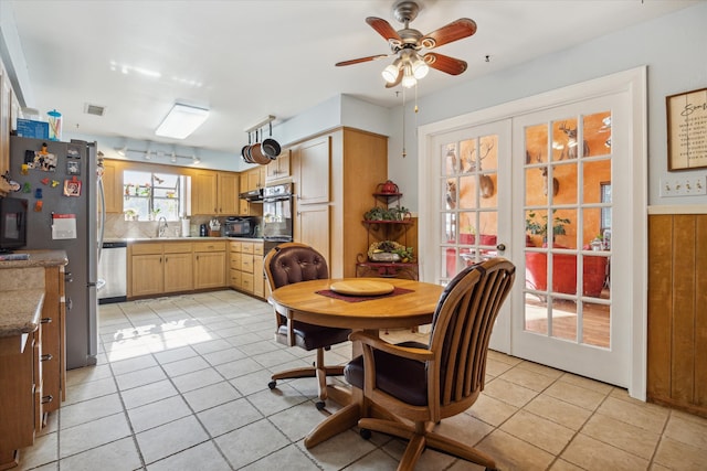 dining space with french doors, light tile patterned floors, ceiling fan, and sink