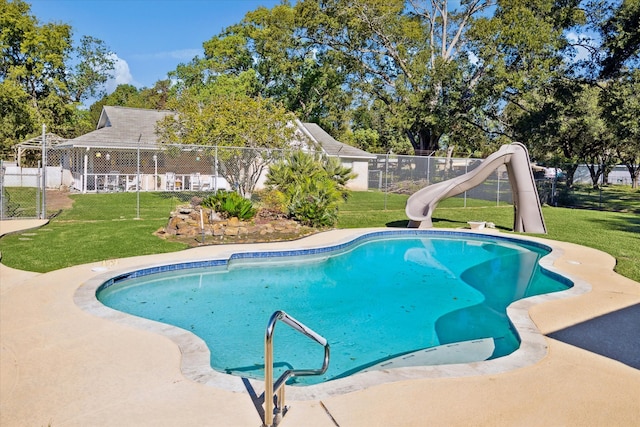 view of pool with a lawn and a water slide