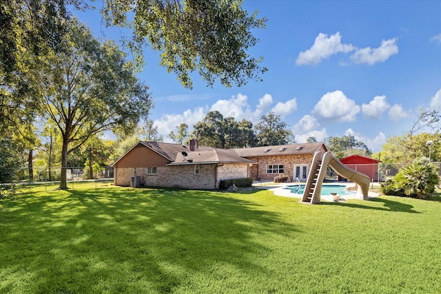 back of property with a lawn and central AC unit