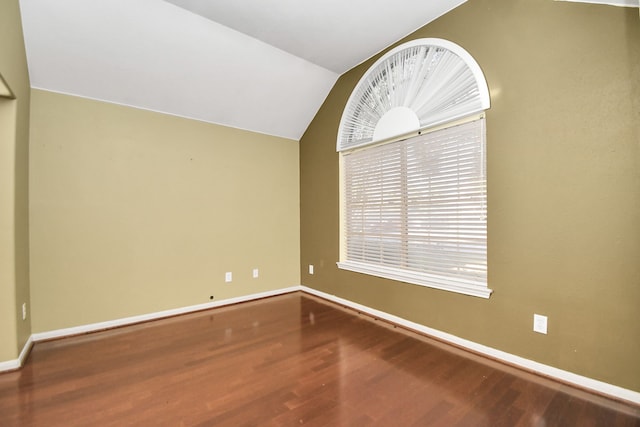 spare room featuring lofted ceiling and hardwood / wood-style flooring