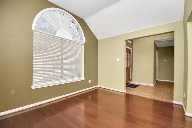 empty room featuring hardwood / wood-style floors and lofted ceiling