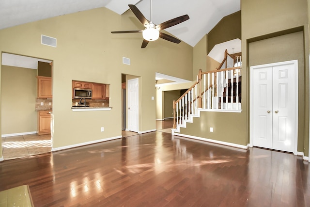 unfurnished living room featuring ceiling fan, light wood-type flooring, and high vaulted ceiling