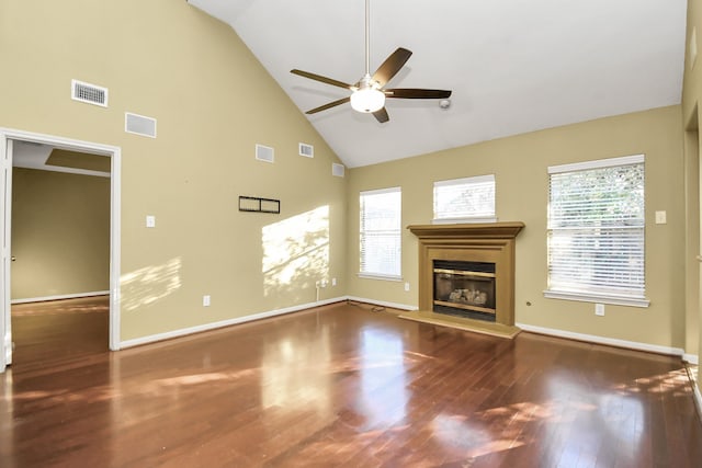 unfurnished living room featuring dark hardwood / wood-style flooring, high vaulted ceiling, plenty of natural light, and ceiling fan