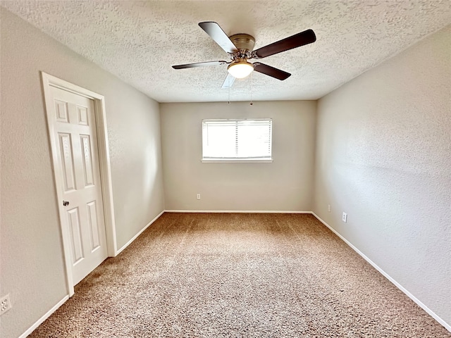 empty room with carpet flooring, ceiling fan, and a textured ceiling