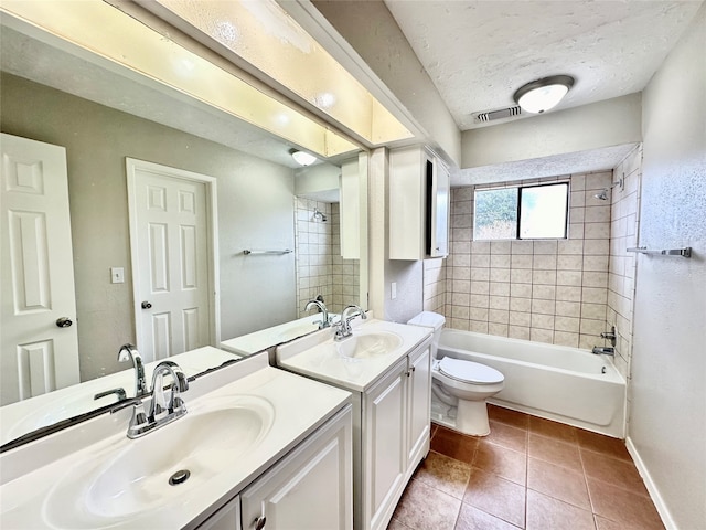 full bathroom with tile patterned flooring, a textured ceiling, toilet, vanity, and tiled shower / bath