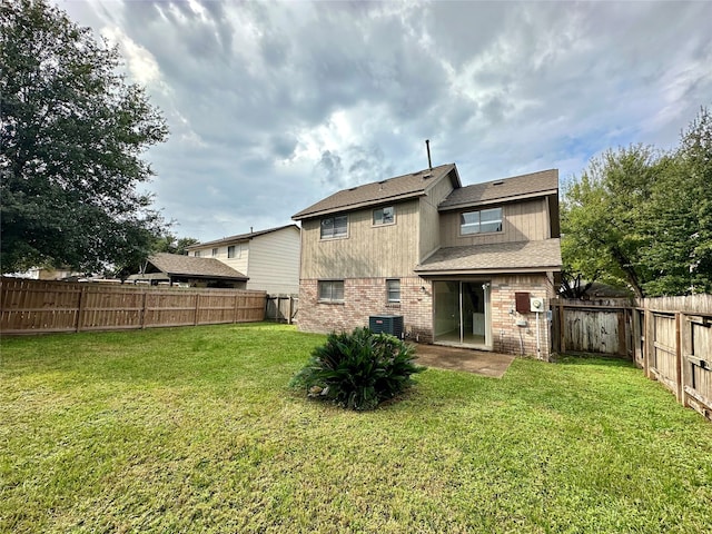 back of property featuring a yard and central air condition unit