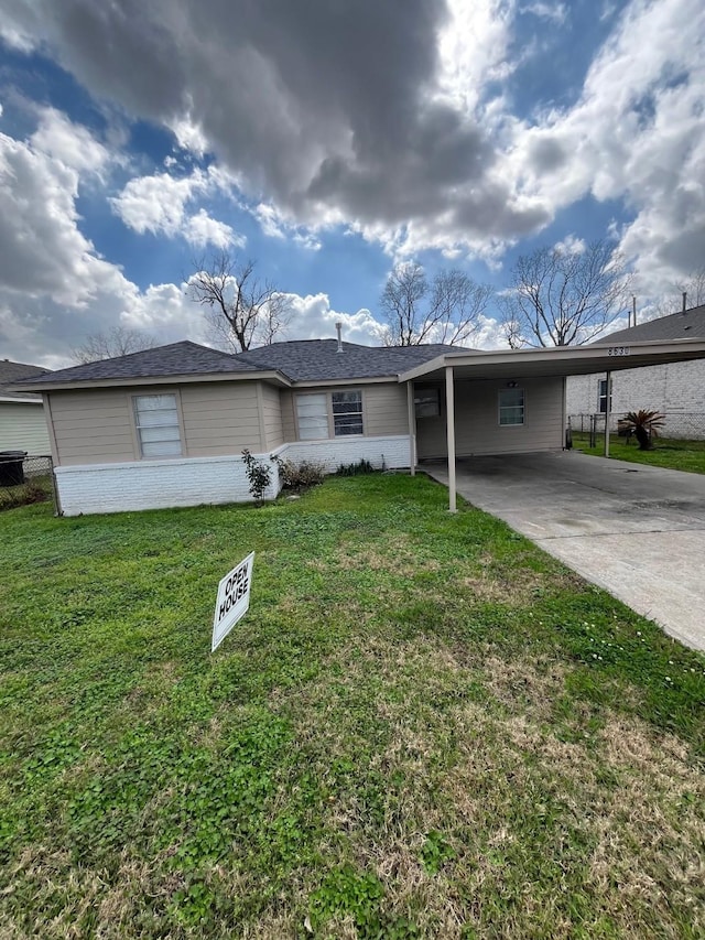 ranch-style home featuring a front lawn and a carport