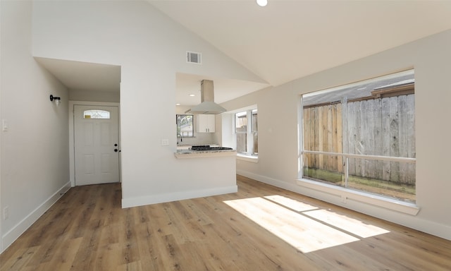 unfurnished living room featuring light hardwood / wood-style flooring, high vaulted ceiling, and sink