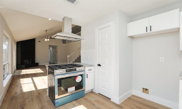 kitchen featuring lofted ceiling, island range hood, white cabinets, light hardwood / wood-style flooring, and gas stove