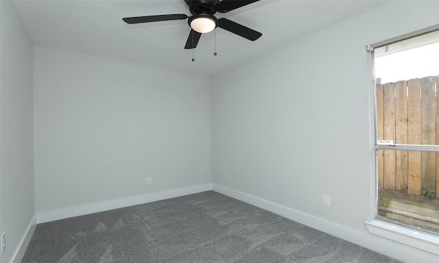 empty room with ceiling fan and dark carpet