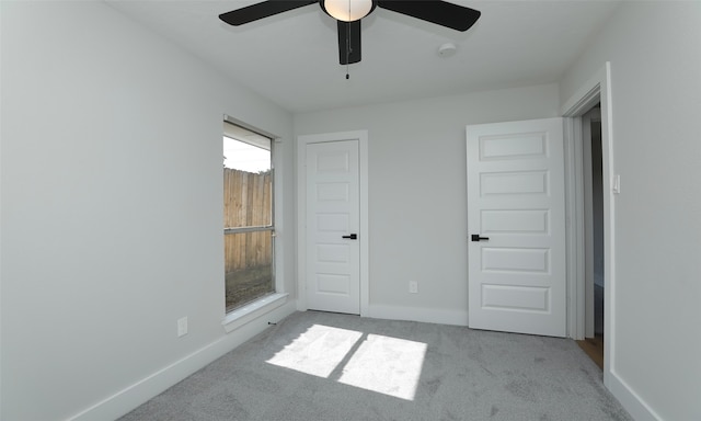 unfurnished bedroom featuring light carpet and ceiling fan