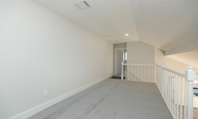 additional living space with light colored carpet and vaulted ceiling