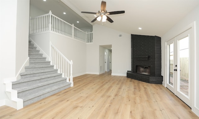 unfurnished living room with ceiling fan, a fireplace, high vaulted ceiling, and light hardwood / wood-style floors