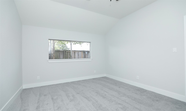 carpeted empty room with lofted ceiling