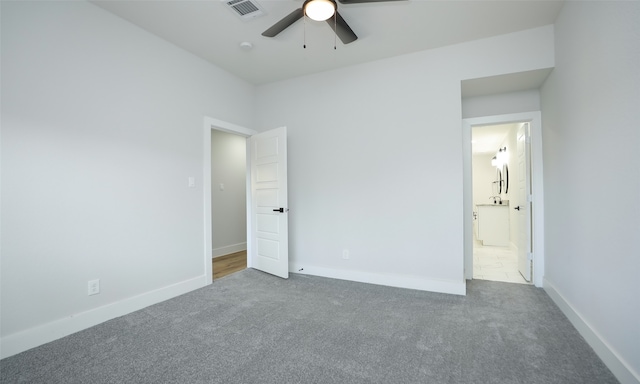 unfurnished bedroom with carpet floors, ensuite bath, and ceiling fan