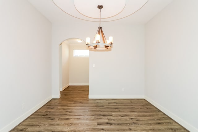 unfurnished dining area with a chandelier and dark wood-type flooring