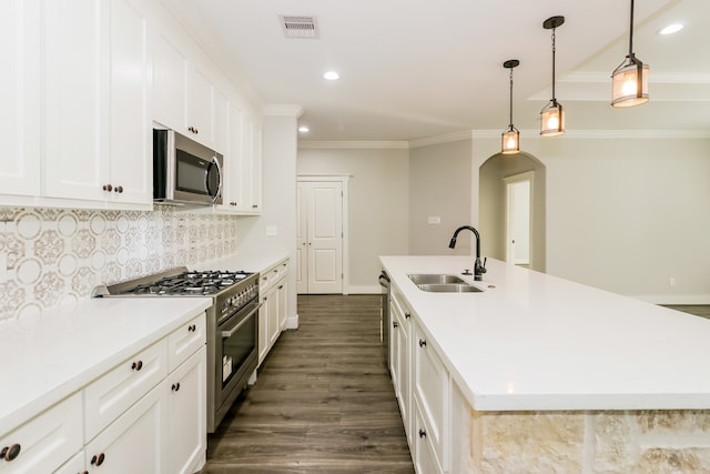 kitchen featuring a center island with sink, decorative backsplash, sink, and stainless steel appliances