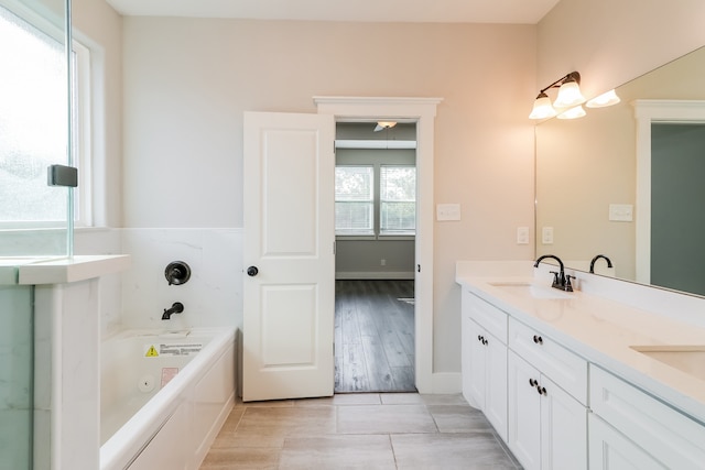 bathroom with vanity, a bath, and hardwood / wood-style flooring