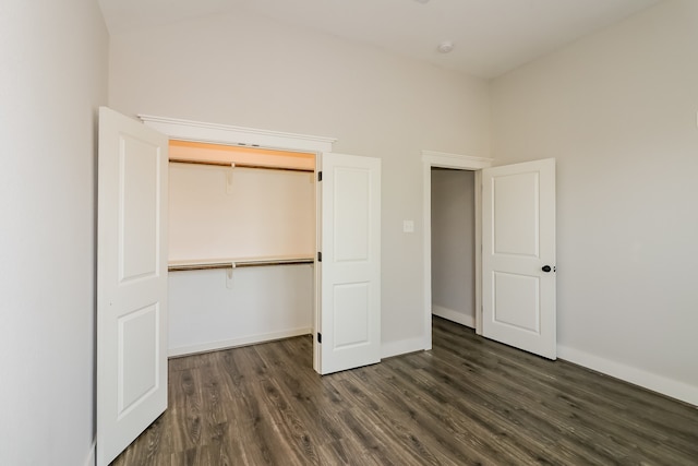 unfurnished bedroom featuring dark hardwood / wood-style floors, a high ceiling, and a closet