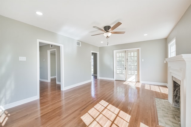 unfurnished living room featuring ceiling fan and light hardwood / wood-style flooring