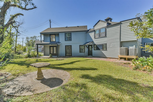 rear view of house with french doors and a yard