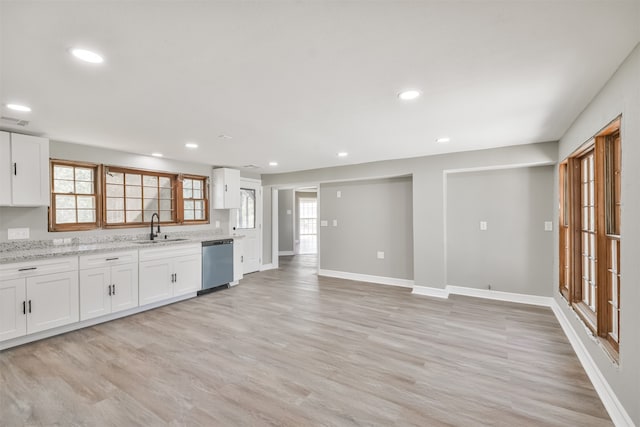 kitchen featuring white cabinetry, stainless steel dishwasher, plenty of natural light, and sink