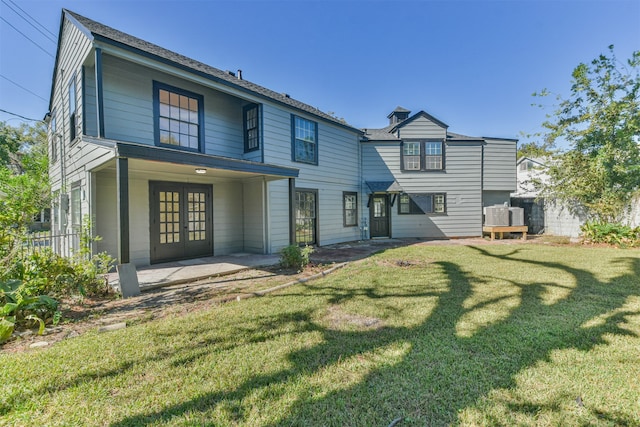 back of property featuring a lawn, a patio area, and french doors