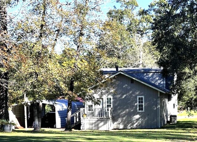 view of side of home with a lawn and cooling unit