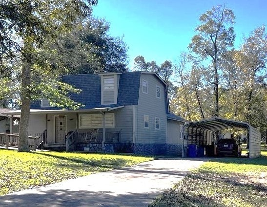 view of front of property with a porch, a front yard, and a carport