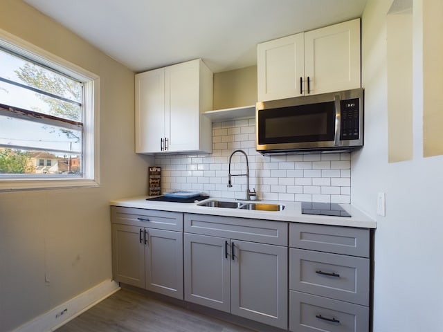 kitchen featuring sink, dark hardwood / wood-style floors, gray cabinets, decorative backsplash, and white cabinets