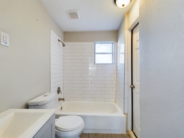 full bathroom with hardwood / wood-style floors, vanity, toilet, and tiled shower / bath