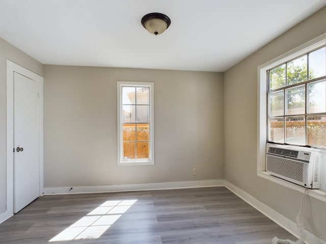 unfurnished room featuring cooling unit and hardwood / wood-style flooring